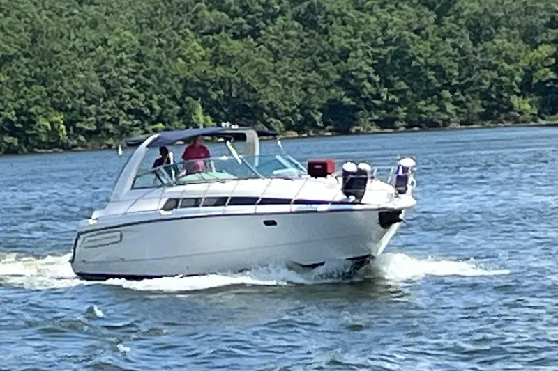 Slide: The Image of 1997 Avanti 4085 Sunbridge cruising on a scenic lake with lush green forest backdrop. - 1