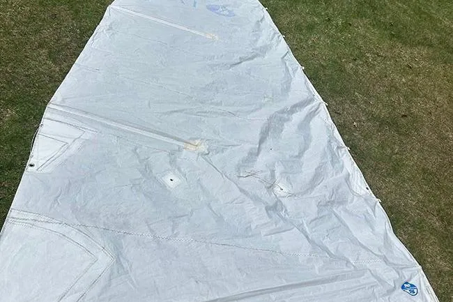 Slide: The Image of White sail on grass, Marlow-Hunter 170, 2008 model, showing wear and tear. - 10
