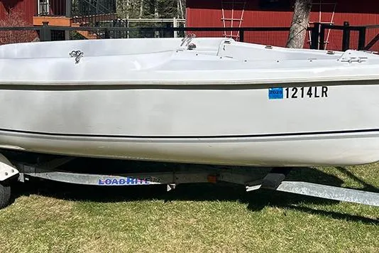 Slide: The Image of 2008 Marlow-Hunter 170 sailboat on trailer, parked on grass with red building background. - 5