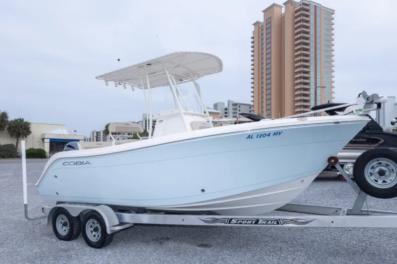 The Image of 2016 Cobia 201 Center Console boat on trailer, urban background. - 0