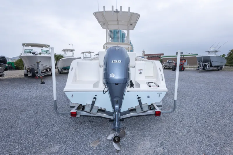 Slide: The Image of 2016 Cobia 201 Center Console boat with 150 horsepower engine, parked on gravel lot. - 13