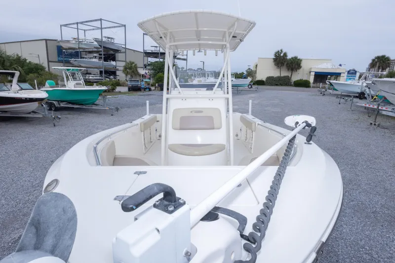 Slide: The Image of 2016 Cobia 201 Center Console boat in a marina, showcasing spacious deck and seating. - 17