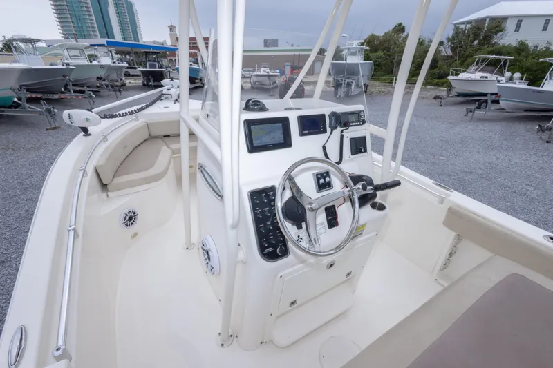 Slide: The Image of 2016 Cobia 201 Center Console boat interior with steering wheel and navigation equipment. - 25