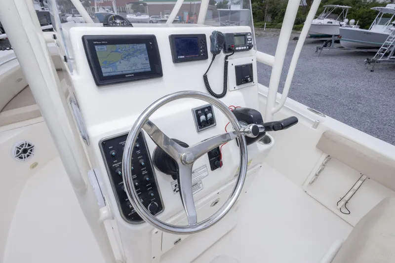 Slide: The Image of 2016 Cobia 201 Center Console boat dashboard with steering wheel and navigation equipment. - 26
