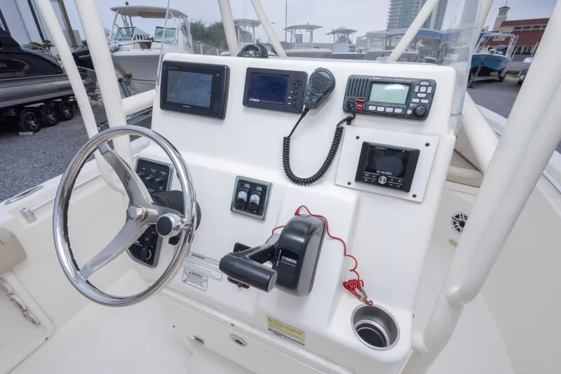 Slide: The Image of 2016 Cobia 201 Center Console boat dashboard with steering wheel and electronic controls. - 27