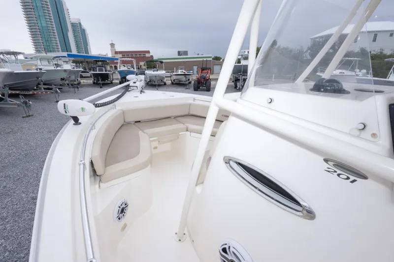 Slide: The Image of 2016 Cobia 201 Center Console boat with seating, parked in a marina. - 30