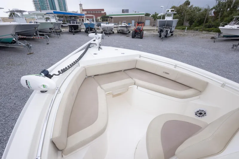 Slide: The Image of 2016 Cobia 201 Center Console boat with spacious seating, parked in a marina. - 31