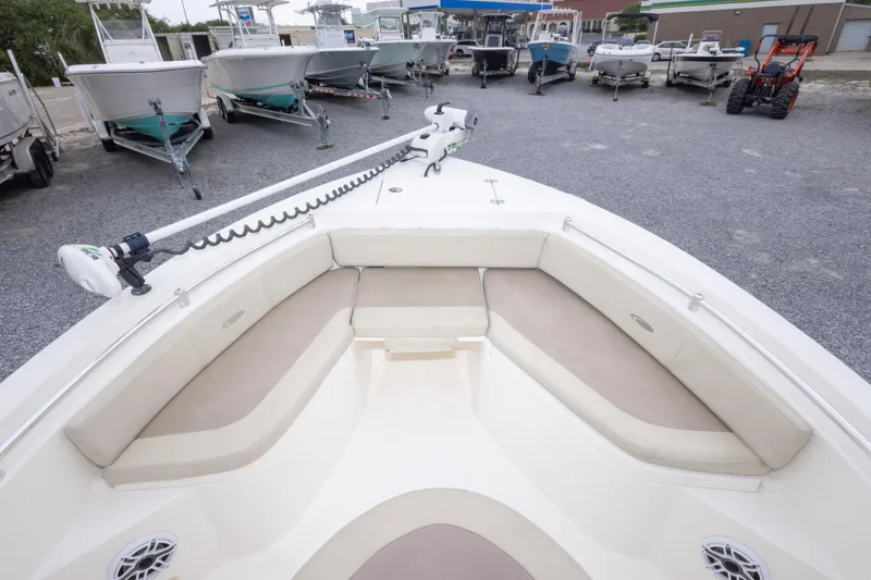 Slide: The Image of 2016 Cobia 201 Center Console boat with spacious bow seating, parked among other boats. - 33