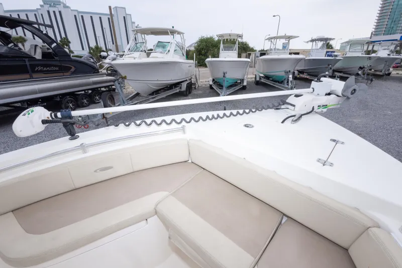 Slide: The Image of 2016 Cobia 201 Center Console boat with trolling motor, parked among other boats. - 34