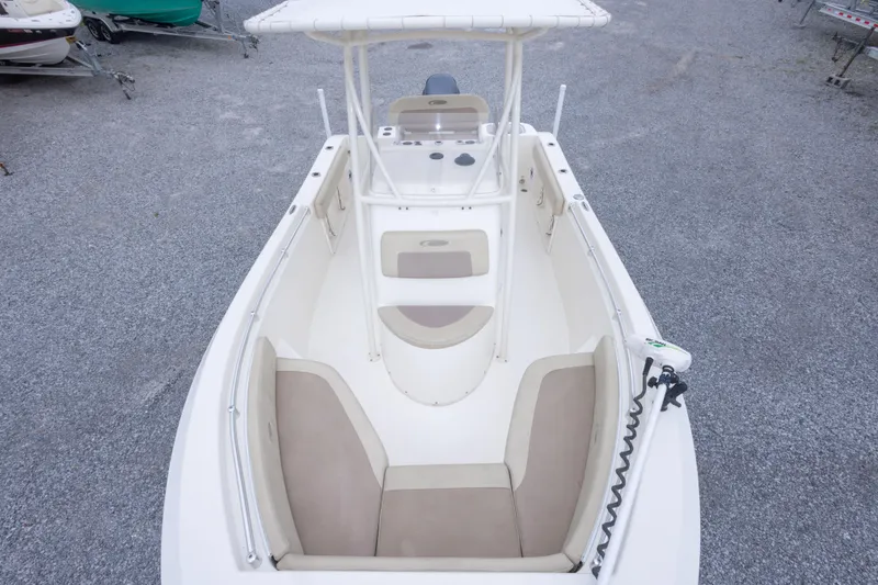 Slide: The Image of 2016 Cobia 201 Center Console boat with beige seating, parked on gravel. - 36