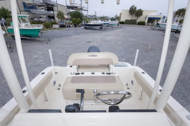 Slide: The Image of 2016 Cobia 201 Center Console boat interior at a marina, showcasing steering and seating area. - 40