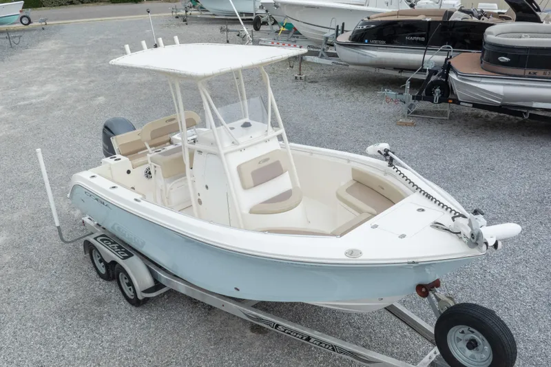Slide: The Image of 2016 Cobia 201 Center Console boat on trailer, parked in a gravel lot. - 9