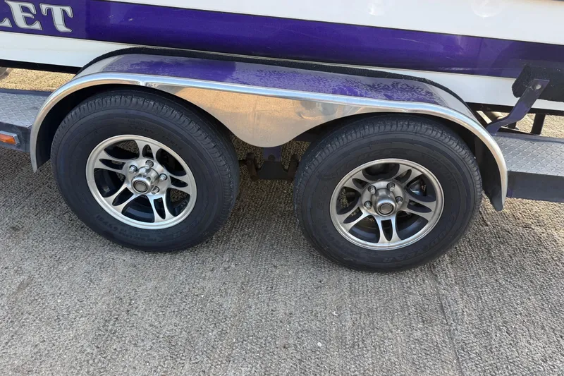 Slide: The Image of Trailer wheels of a 2002 Bullet 21XDC boat on concrete surface. - 18