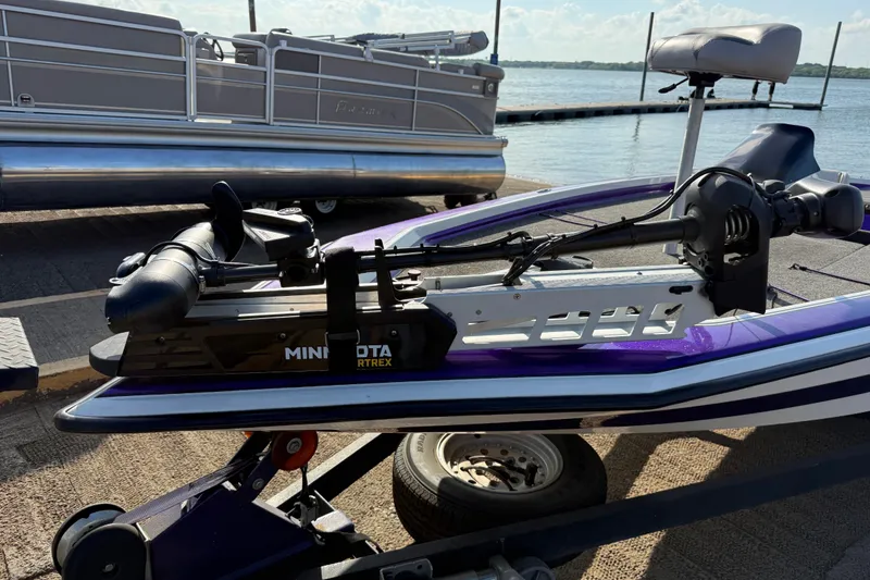 Slide: The Image of 2002 Bullet 21XDC boat with Minn Kota Ultrex trolling motor at a lakeside dock. - 23
