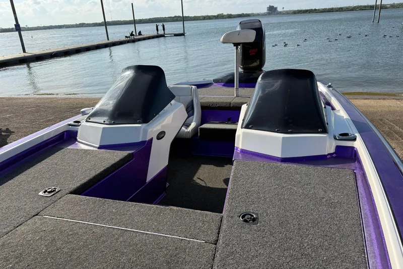 Slide: The Image of 2002 Bullet 21XDC boat with dual consoles, docked by a serene lake. - 26