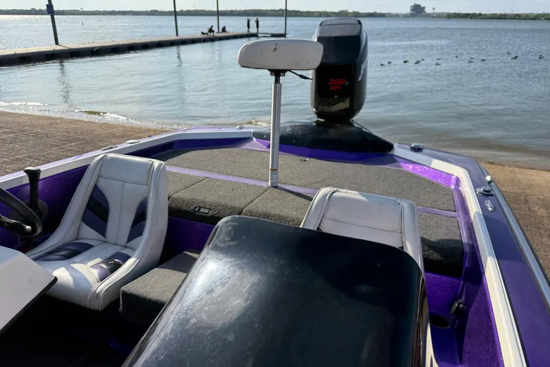 Slide: The Image of 2002 Bullet 21XDC boat with seating, docked by a serene lake. - 27