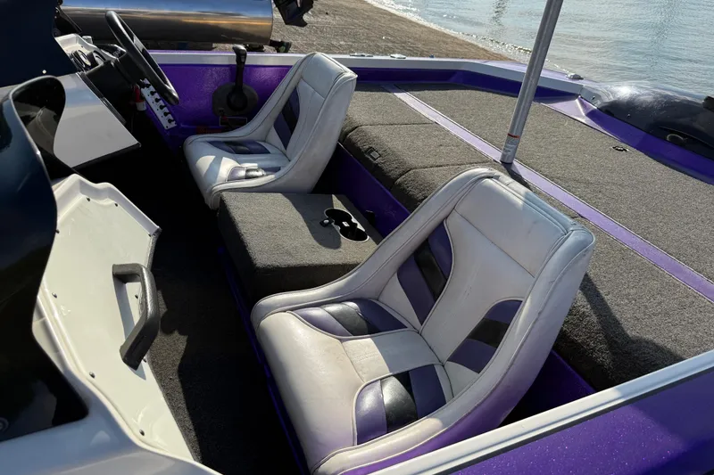 Slide: The Image of 2002 Bullet 21XDC boat interior with dual seats and steering wheel, near water. - 28