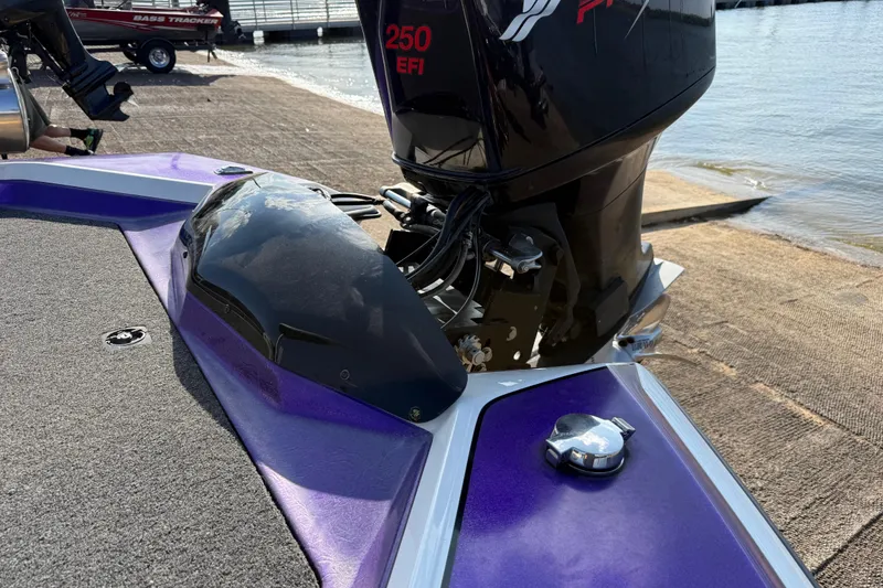 Slide: The Image of Purple Bullet 21XDC boat with 250 EFI engine at a lakeside ramp, 2002 model. - 29