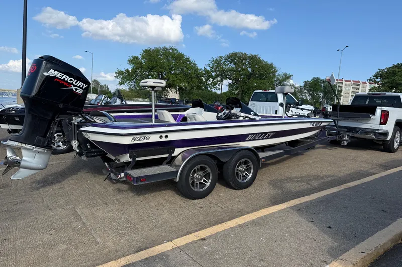 Slide: The Image of 2002 Bullet 21XDC boat with Mercury engine on trailer, parked near trucks. - 9