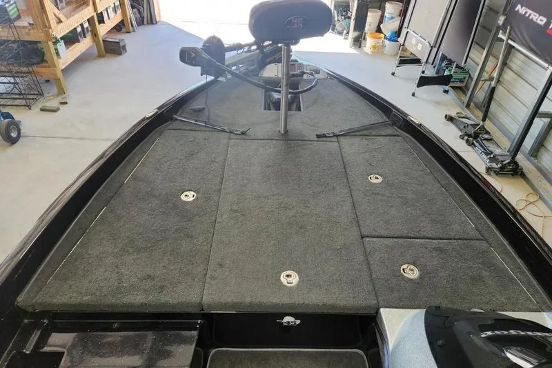 Slide: The Image of 2013 Ranger Z518 Comanche boat deck with storage compartments in a garage setting. - 5