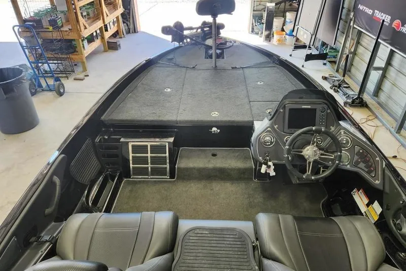 Slide: The Image of 2013 Ranger Z518 Comanche boat interior with steering console and seating in a garage. - 8