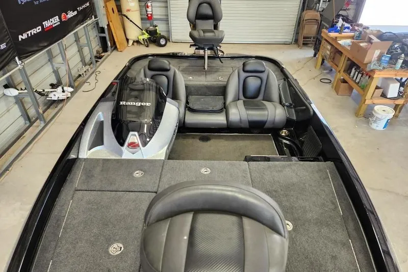 Slide: The Image of 2013 Ranger Z518 Comanche boat interior with seating and storage compartments in a garage. - 9