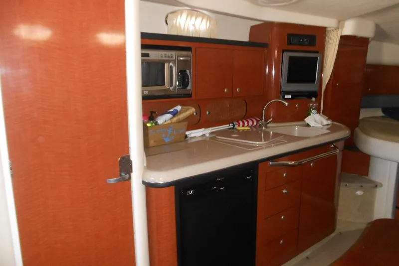 Slide: The Image of 2005 Sea Ray 340 Sundancer interior kitchen with wood cabinetry and modern appliances. - 13