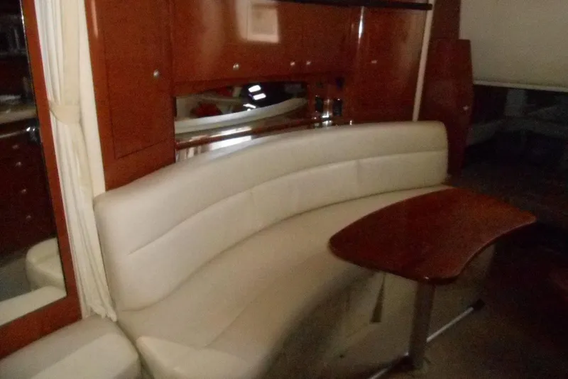 Slide: The Image of Luxurious interior of 2005 Sea Ray 340 Sundancer with curved seating and wooden table. - 14