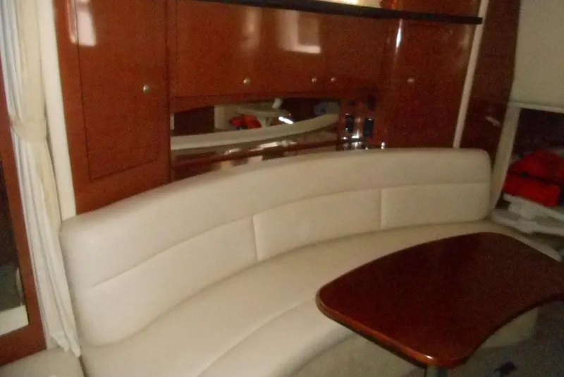Slide: The Image of Interior of 2005 Sea Ray 340 Sundancer with curved seating and wooden table. - 15