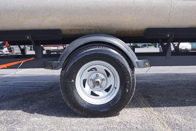 The Image of Trailer wheel of 2025 Sun Tracker Bass Buggy 18 DLX on asphalt surface. - 1
