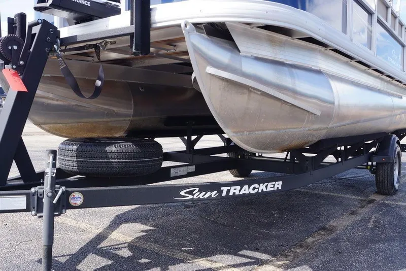 Slide: The Image of 2025 Sun Tracker Bass Buggy 18 DLX pontoon boat on trailer, close-up view. - 6