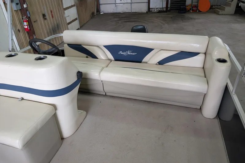 Slide: The Image of 2016 SunChaser Oasis Fish 816 pontoon boat interior with beige seating and steering console. - 6