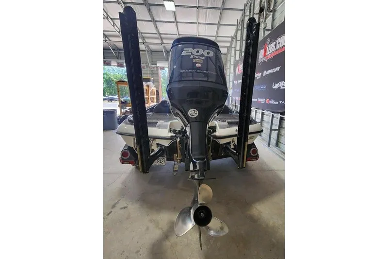 Slide: The Image of 2013 Ranger Z518 Comanche boat with powerful outboard motor in a garage setting. - 6
