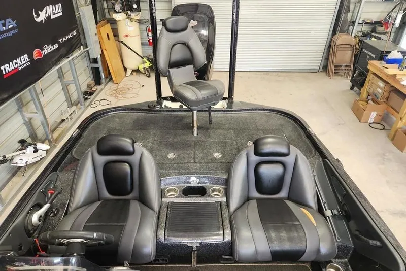 Slide: The Image of 2013 Ranger Z518 Comanche boat interior with dual seats and fishing chair in a garage. - 7