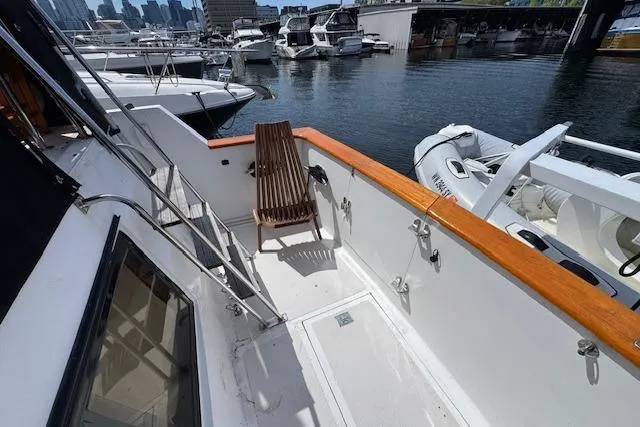 Slide: The Image of 1993 Ocean Alexander 440 Sundeck CPMY yacht deck with wooden chair, docked at marina. - 11