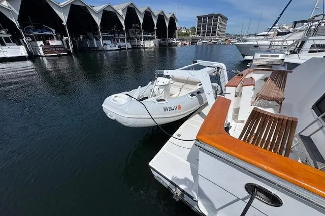 Slide: The Image of 1993 Ocean Alexander 440 Sundeck CPMY docked with inflatable boat, marina backdrop. - 14