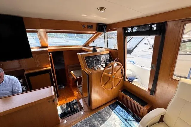 Slide: The Image of Interior of 1993 Ocean Alexander 440 Sundeck CPMY with wooden helm and seating area. - 18