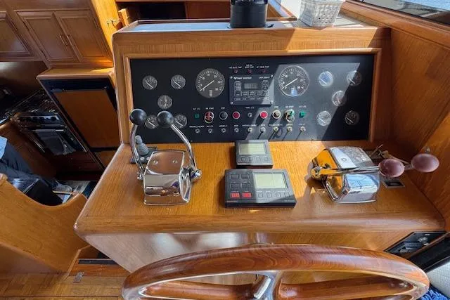 Slide: The Image of 1993 Ocean Alexander 440 Sundeck CPMY helm with wooden wheel and control panel. - 19