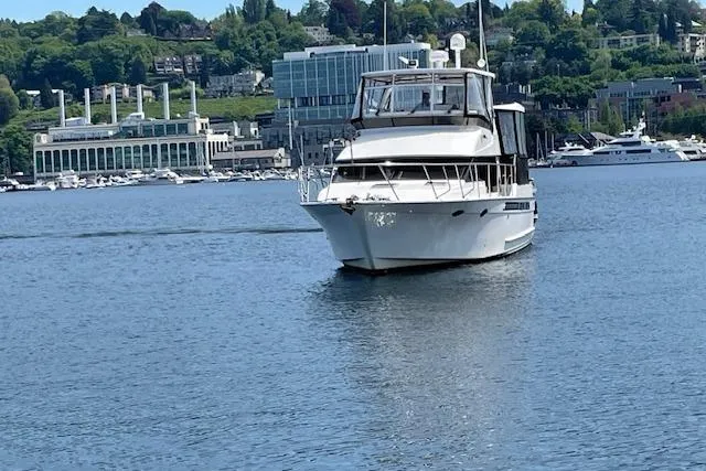 Slide: The Image of Ocean Alexander 440 Sundeck CPMY 1993 yacht on calm water with cityscape background. - 2