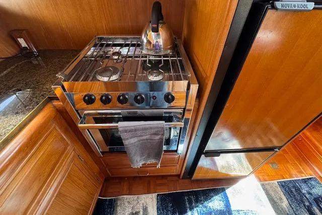 Slide: The Image of 1993 Ocean Alexander 440 Sundeck CPMY kitchen with stove, kettle, and refrigerator. - 22