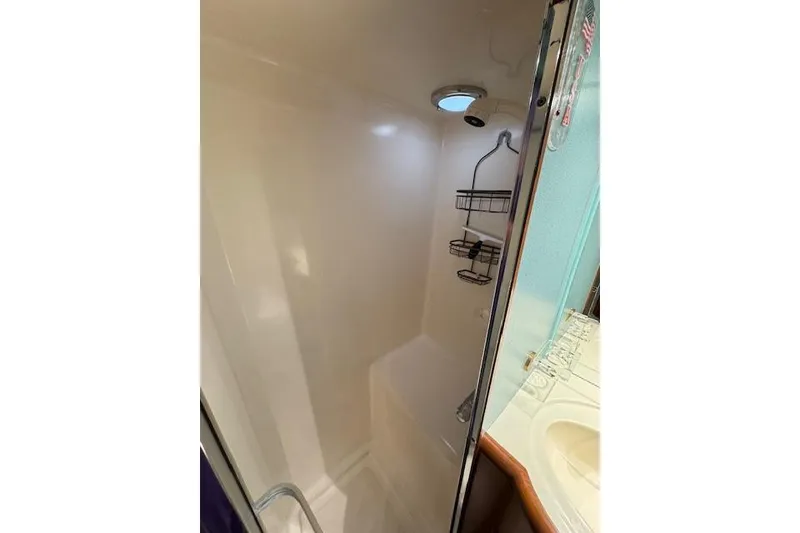 Slide: The Image of Shower area in 1993 Ocean Alexander 440 Sundeck CPMY yacht, featuring sleek design and storage racks. - 28