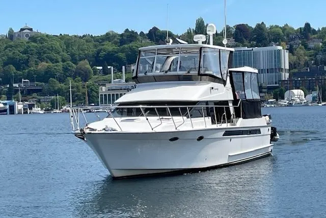 Slide: The Image of 1993 Ocean Alexander 440 Sundeck CPMY yacht on calm water, surrounded by greenery and buildings. - 3
