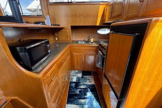 Slide: The Image of 1993 Ocean Alexander 440 Sundeck CPMY kitchen with wooden cabinetry and modern appliances. - 30