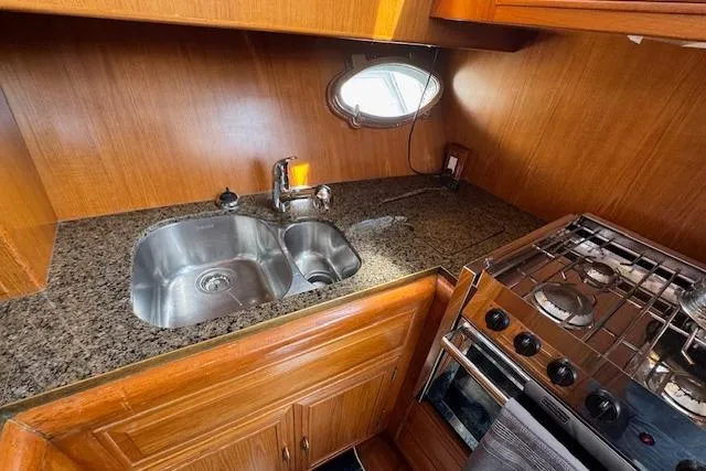 Slide: The Image of 1993 Ocean Alexander 440 Sundeck CPMY kitchen with granite countertop, stainless steel sink, and stove. - 31