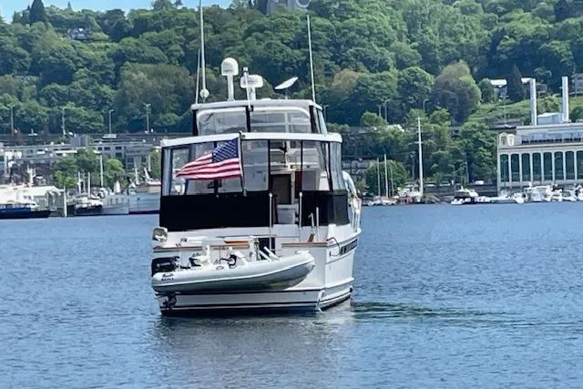 Slide: The Image of 1993 Ocean Alexander 440 Sundeck CPMY yacht on a serene lake with lush green backdrop. - 5