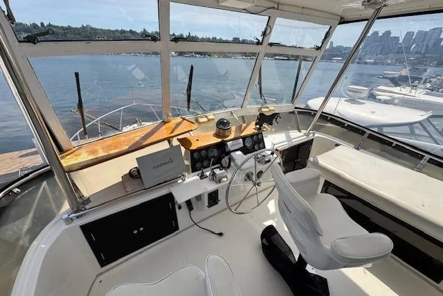 Slide: The Image of Cockpit view of 1993 Ocean Alexander 440 Sundeck CPMY yacht with scenic waterfront backdrop. - 7