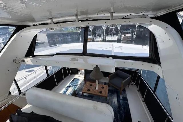 Slide: The Image of 1993 Ocean Alexander 440 Sundeck CPMY interior with seating and table, docked at marina. - 8
