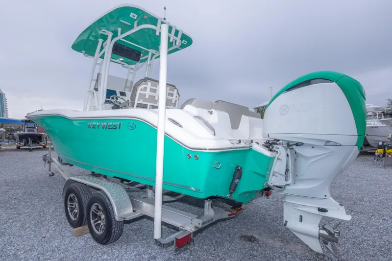 Slide: The Image of 2023 Key West 239 FS boat on trailer, featuring a vibrant teal hull and Yamaha outboard motor. - 15