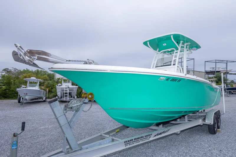 Slide: The Image of 2023 Key West 239 FS boat on trailer, vibrant teal hull, parked outdoors. - 17