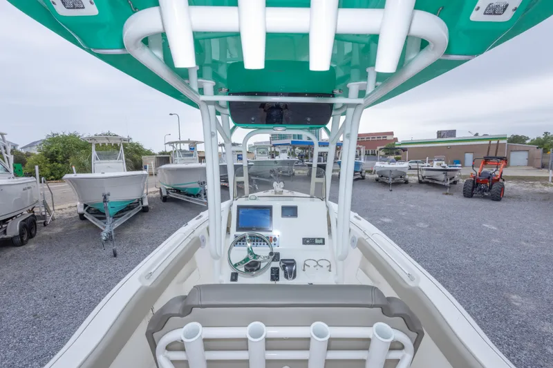 Slide: The Image of 2023 Key West 239 FS boat interior with console and seating, parked among other boats. - 22